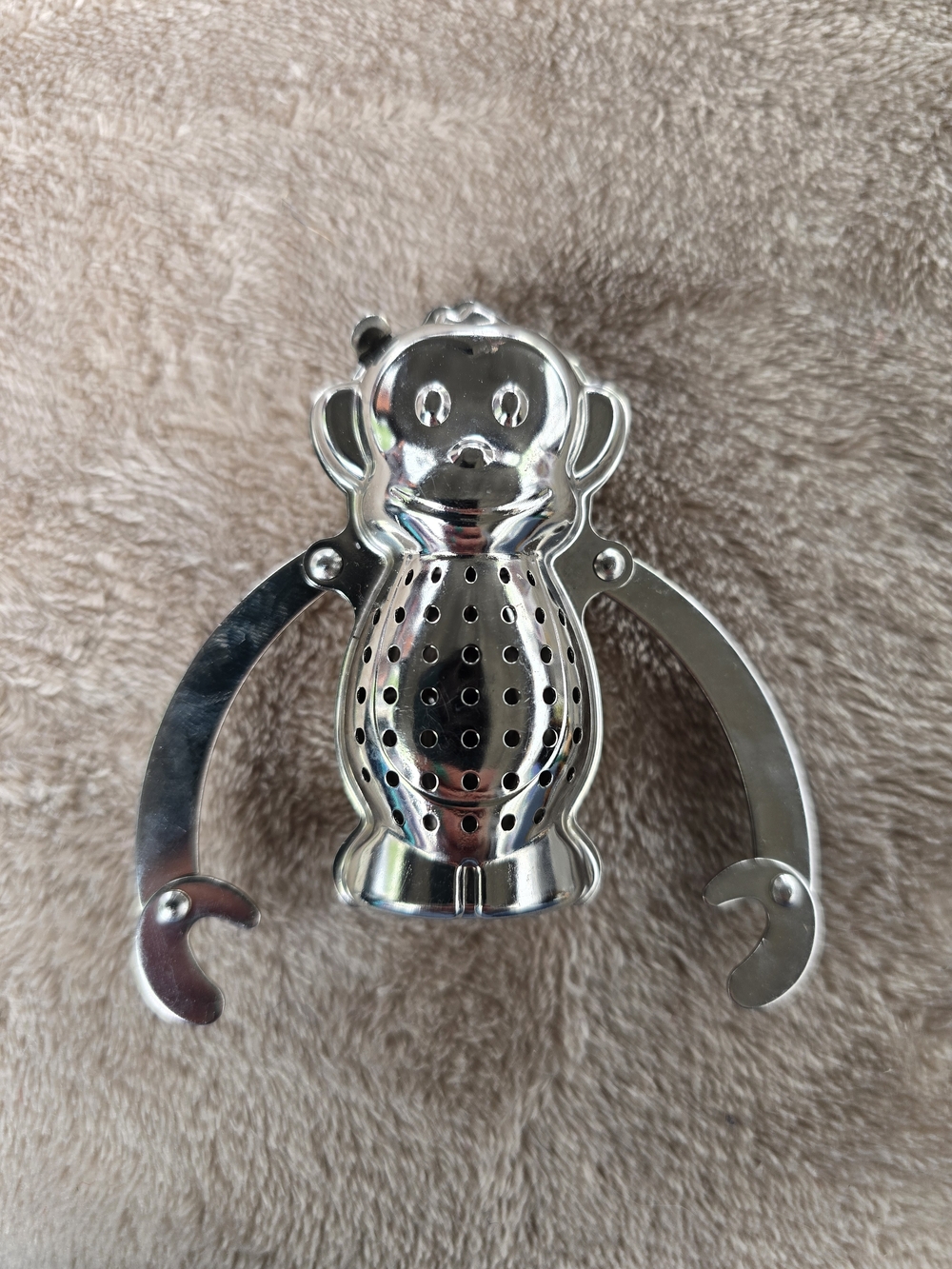 Kikkerland Monkey Tea Infuser in a shiny silver finish.